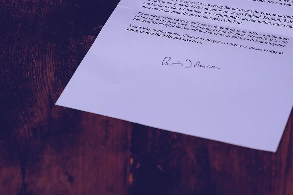 Foto de papel com texto impresso sobre uma mesa de madeira representando o que é comunicado
