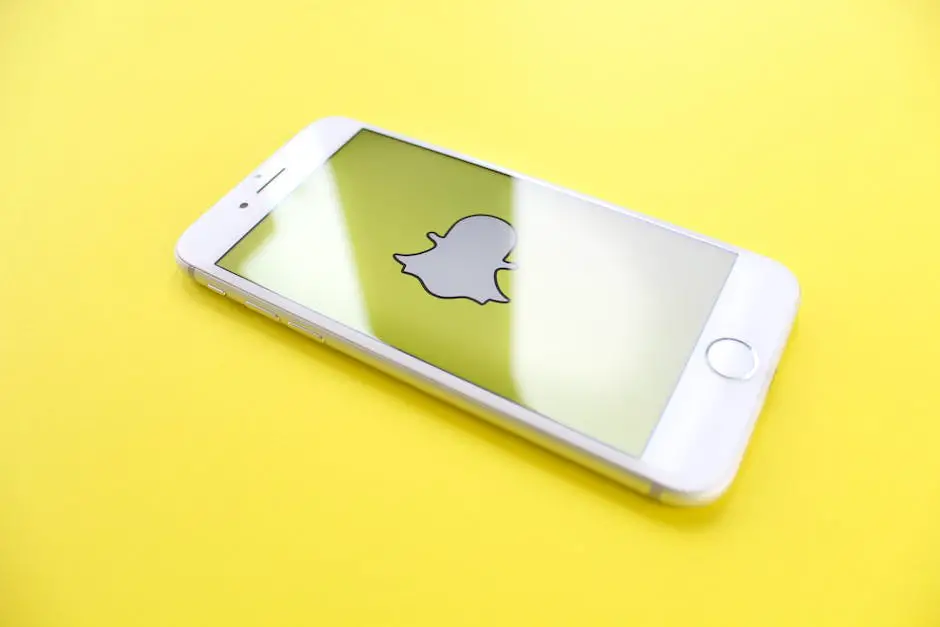 smartphone com logo do snapchta na tela e fundo amarelo para ilustrar a escolha dos canais no plano de comunicação