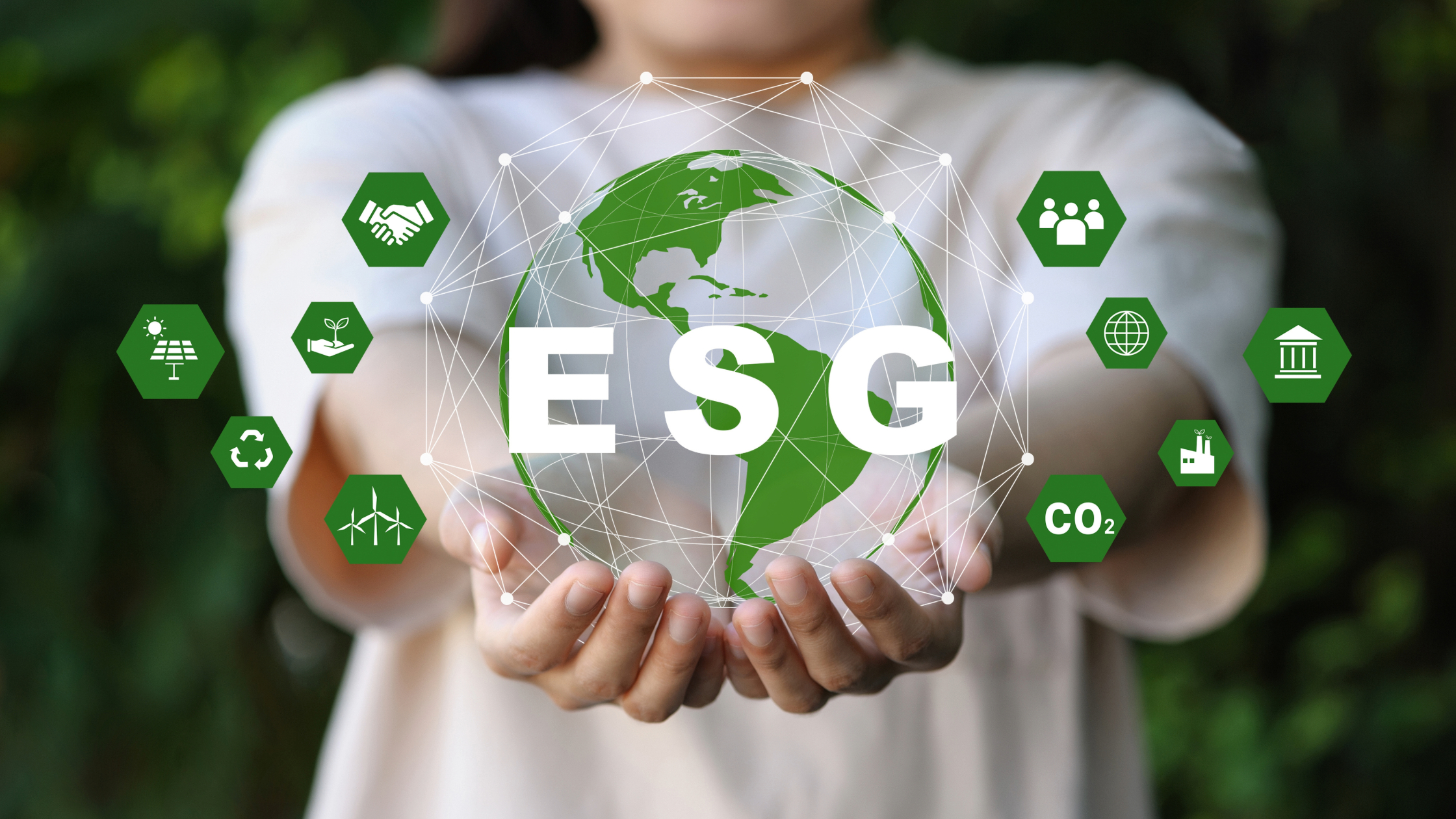 detalhe de mãos de uma pessoa de camiseta branca demonstrando gráficos para ilustrar o ESG na comunicação organizacional