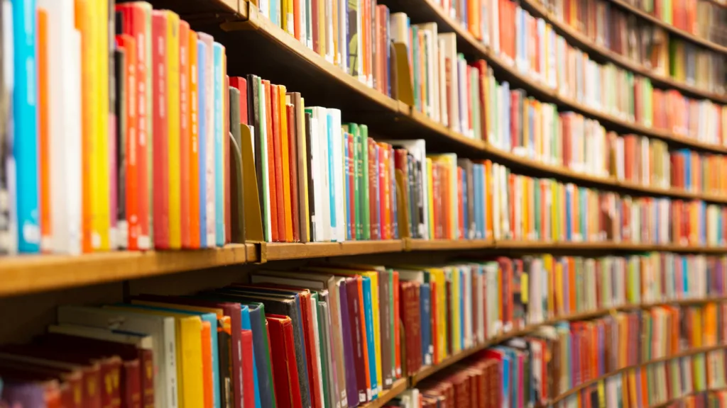 foto de uma estante comprida e cheia de livros para ilustrar as teorias da comunicação